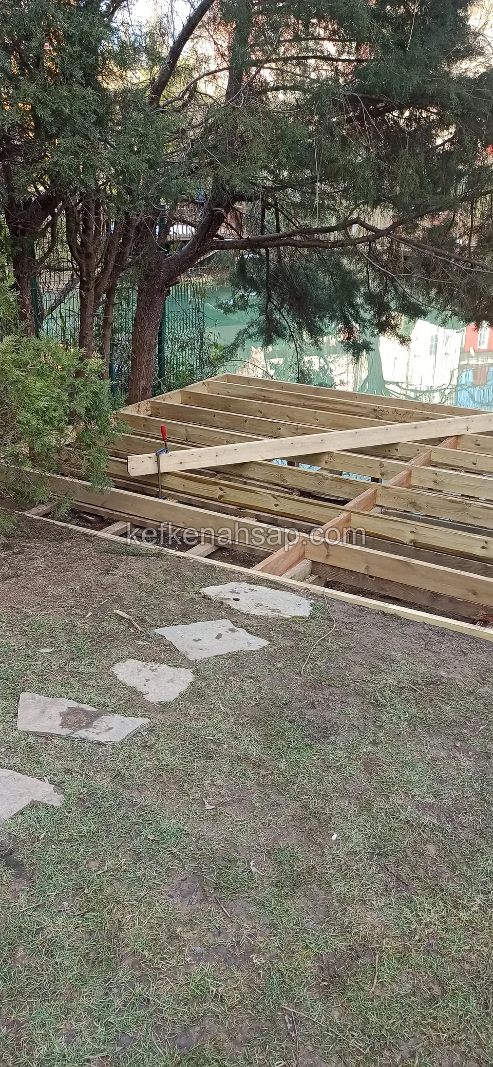 هيكل عوارض ديكينغ تحت شجرة يُوصَل إليه بممر من حجارة العبور عبر العشب