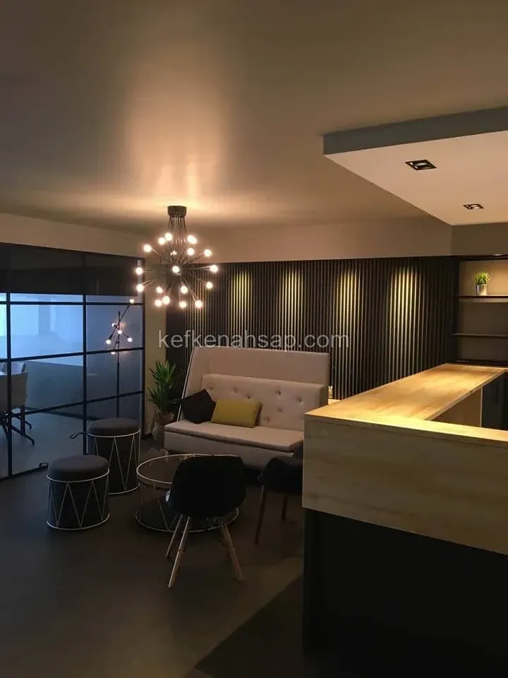 Ofis bekleme alanında ahşap karşılama bankosu, çıtalı koyu duvar kaplaması ve oturma alanı.