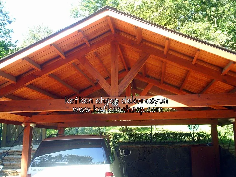 Bahçede park halindeki aracın üzerini örten beşik çatılı masif ahşap otopark sundurması.