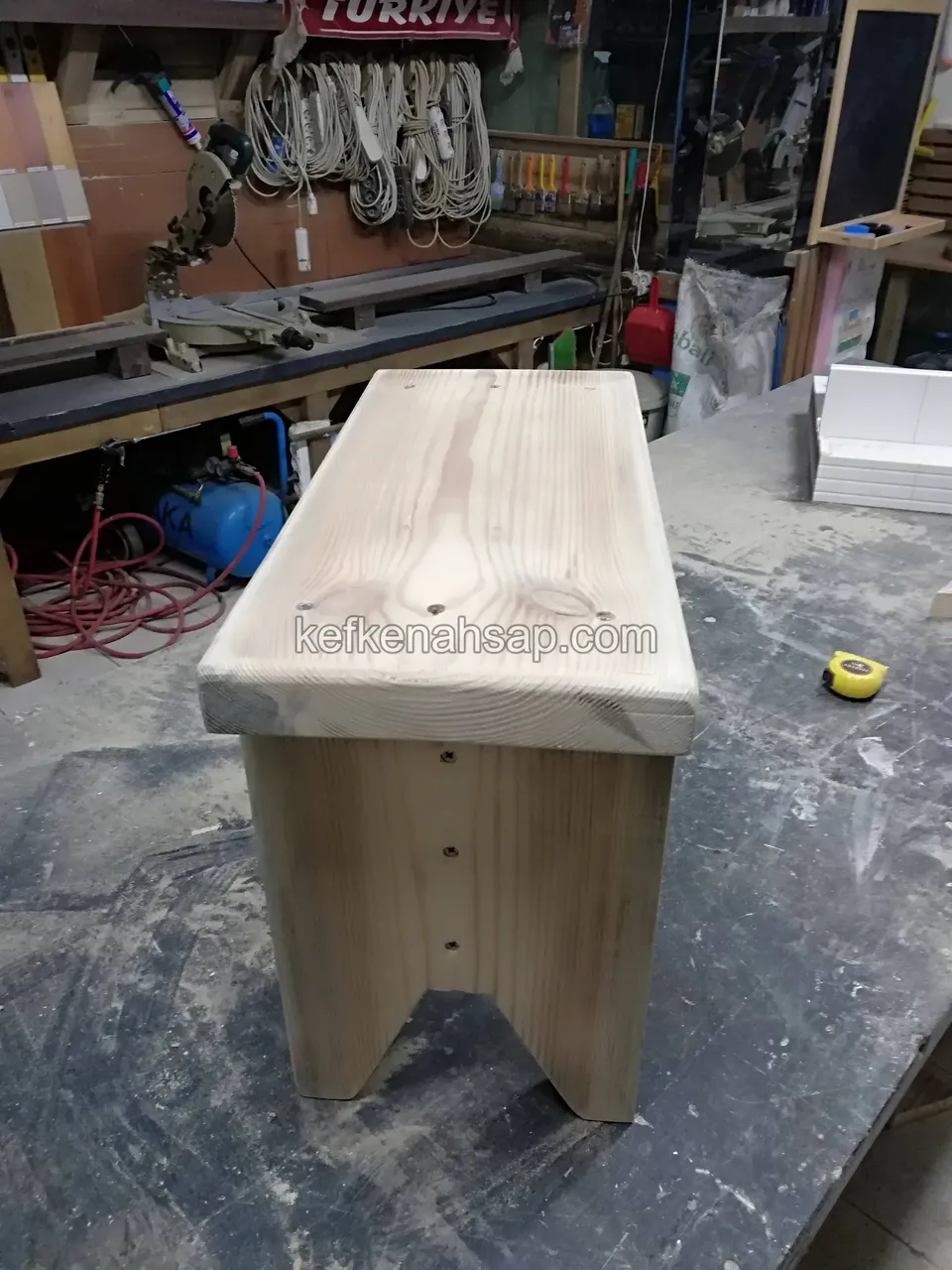 Light timber stool without varnish standing on the workshop bench