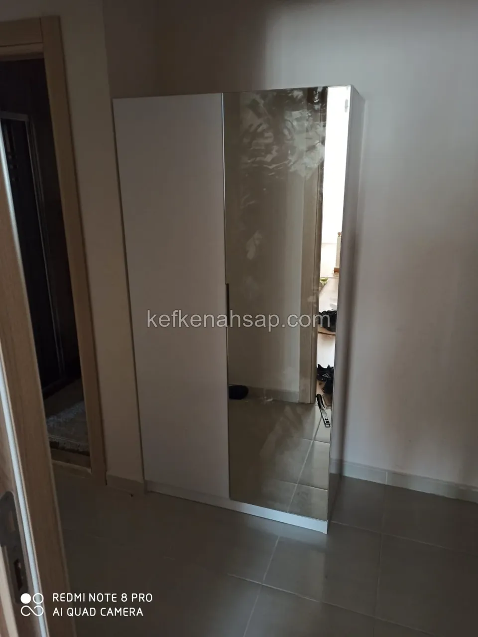 Giriş holünde duvara yaslı, bir kapağı beyaz diğeri aynalı iki kapaklı uzun dolap