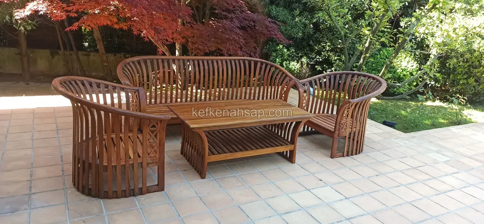 Curved sofa and two armchairs with vertical slats and a low table on a tiled garden terrace