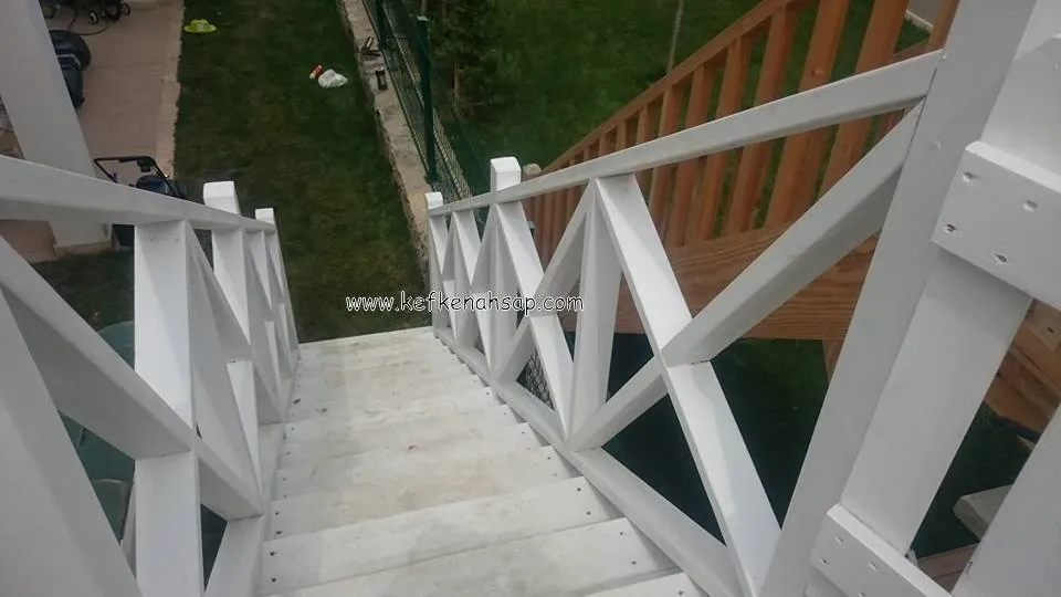 Bahçeye inen beyaz boyalı ahşap merdiven ve çapraz çıtalı korkuluk, sağda doğal renkli ahşap başka bir merdiven