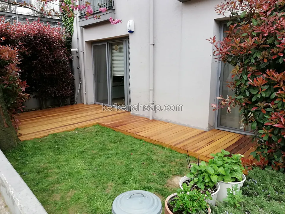 Orange-toned timber deck strip along a lawn in front of a building entrance