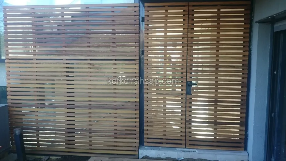 Bina girişinde yatay çıtalı ahşap bölme ve aynı desende iki kanatlı kapı