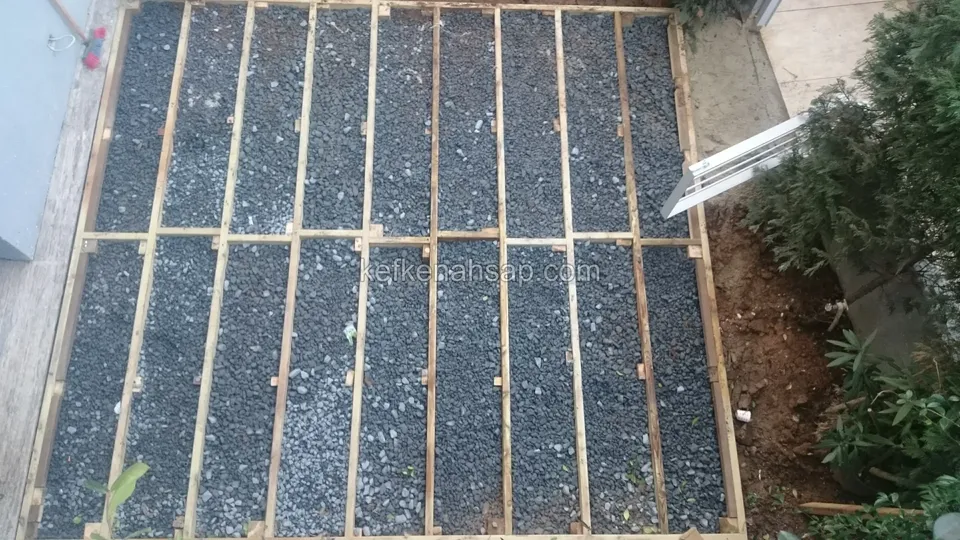 Timber deck substructure with the gaps between joists filled with gravel, seen from above