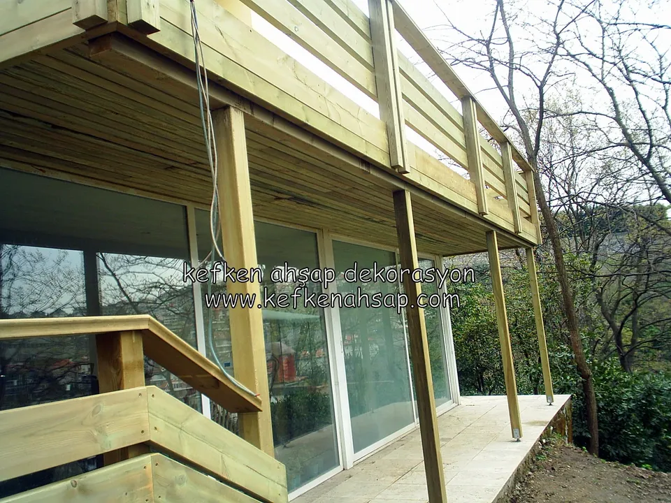 Balcony on timber posts above a glass-fronted building, with timber railing