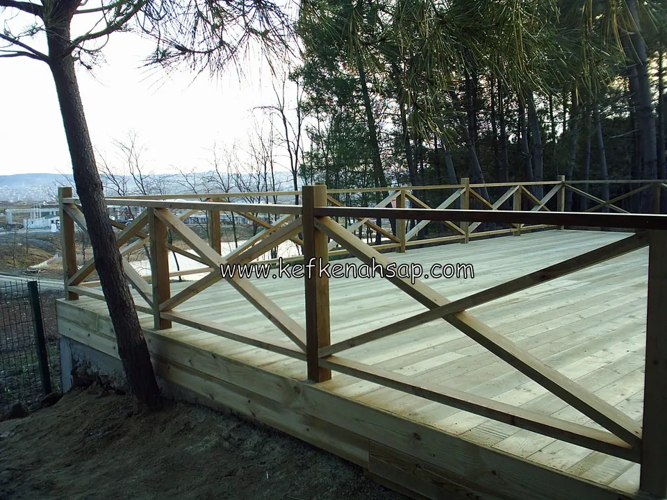 Wide raised timber deck with cross-braced railings, set among pine trees