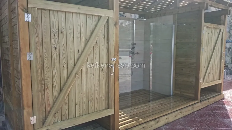 Duş kabininin çaprazlı ahşap kapı kanadı, menteşeleri ve yanındaki cam bölme, yakın görünüm