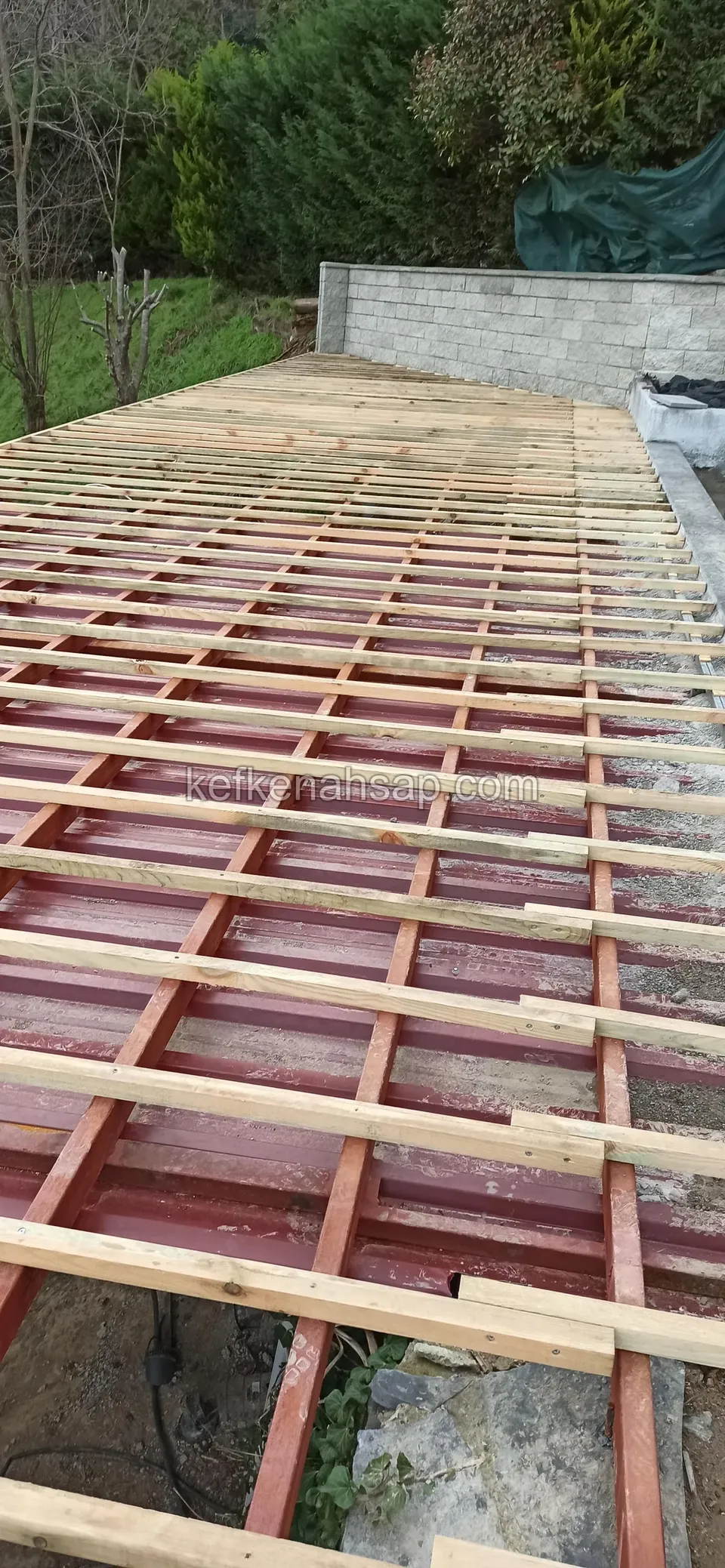Red steel frame with timber battens set crosswise on top