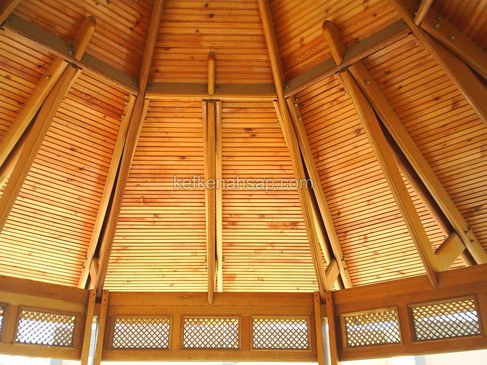 Inside a polygonal gazebo: rafters meeting at the centre, a timber-lined ceiling and lattice panels at the eaves