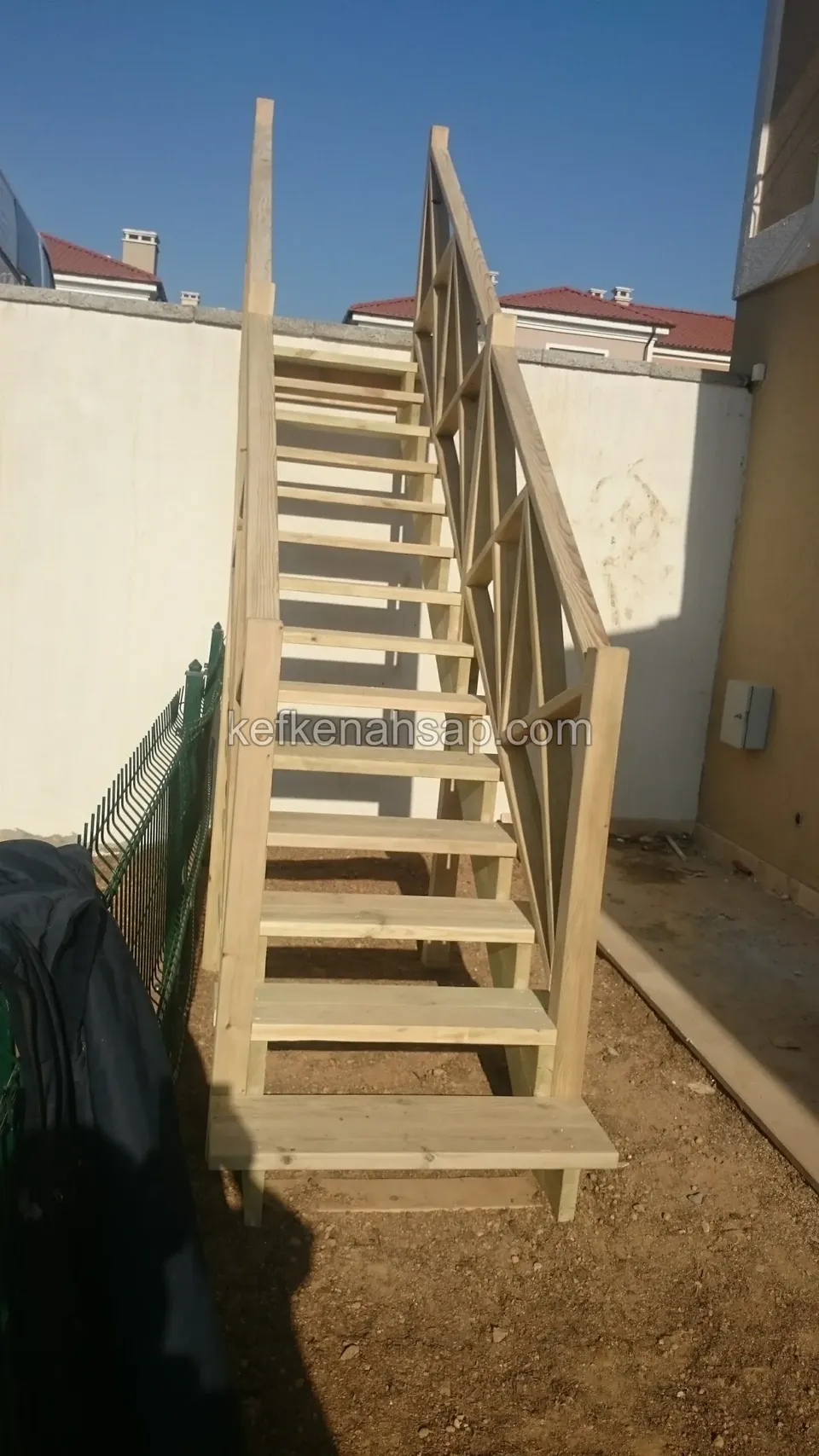 Dar geçitte önden görünen ahşap basamaklar ve sağ yanda çaprazlı korkuluk; sol tarafta henüz korkuluk yok