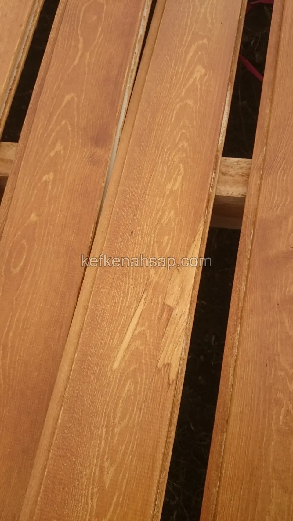 Dik çekilmiş turuncu tonlu deck tahtaları, aralıktan altta çapraz duran açık renkli taşıyıcı çıta görünüyor