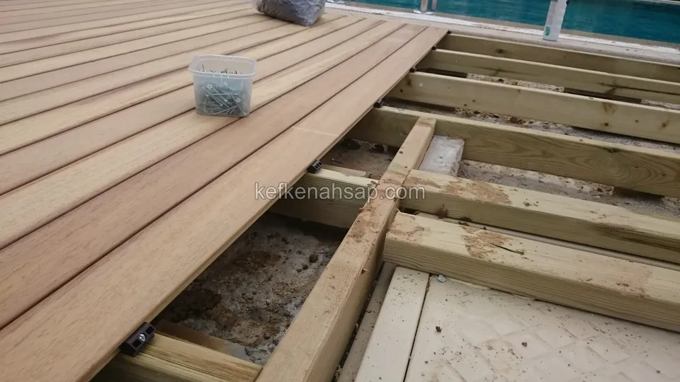 Yakın çekimde kirişler üzerine döşenmiş deck tahtaları, yanında vida kabı ve açıkta kalan çerçeve gözleri