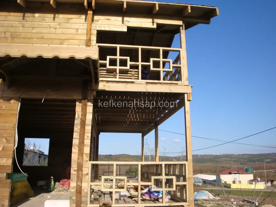 Yapımı süren ahşap evde geometrik desenli korkuluklar ve henüz kapatılmamış alt kat