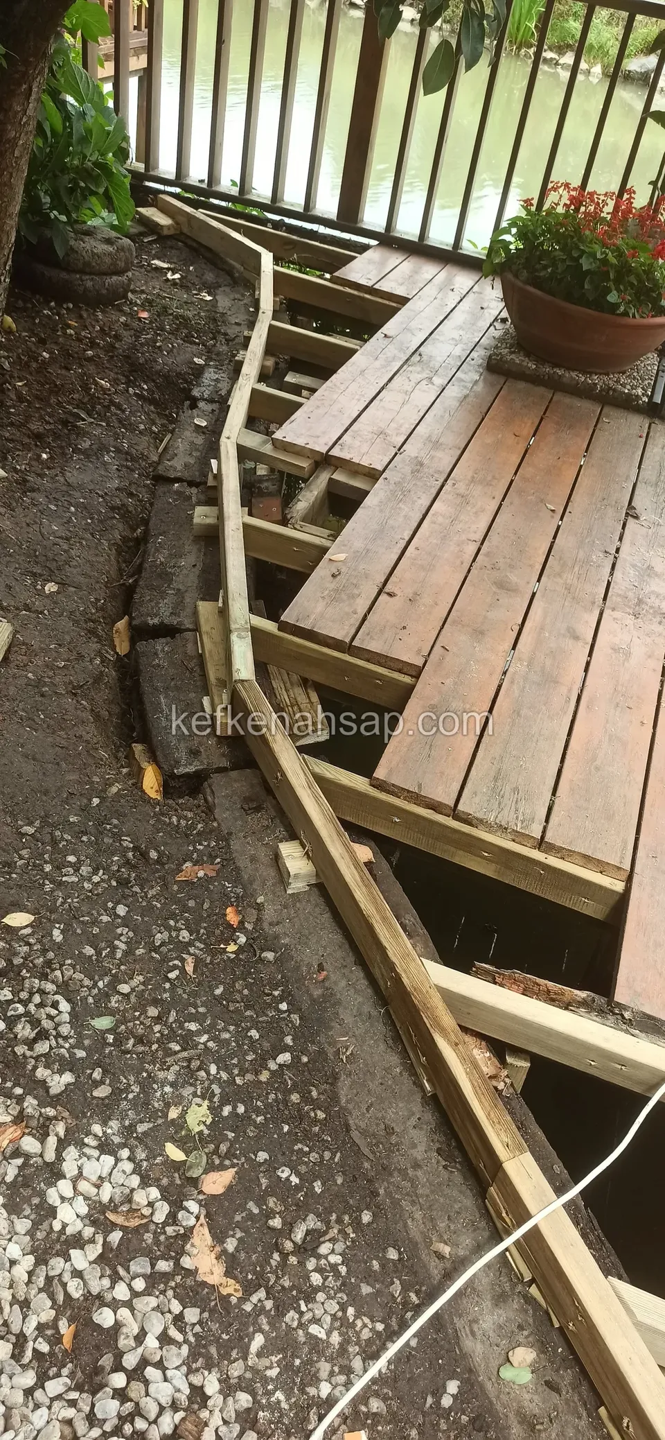 Stepped panel deck boarding along a curved line with timber edge beams, a gravel edge and a flower pot