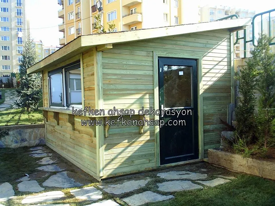 Bahçede tek eğimli çatılı, camlı kapılı emprenyeli ahşap büfe kulübesi.