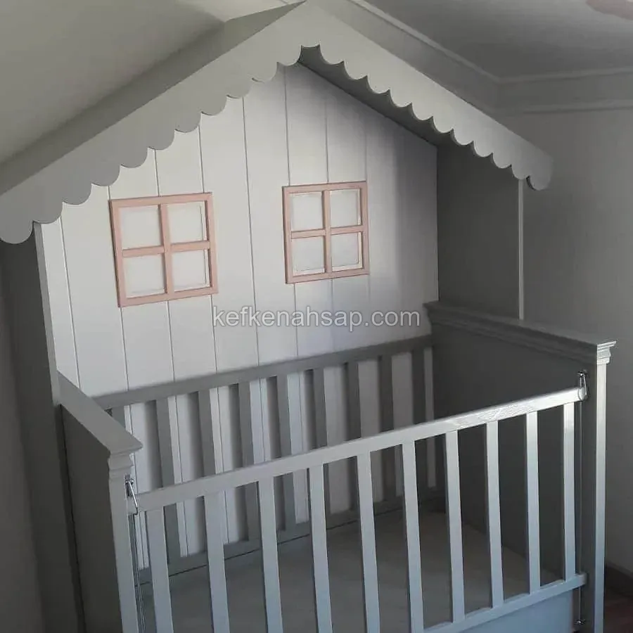 Gri ve beyaz tonlarında boyalı, çatılı ve pencereli ev formunda ahşap bebek karyolası.