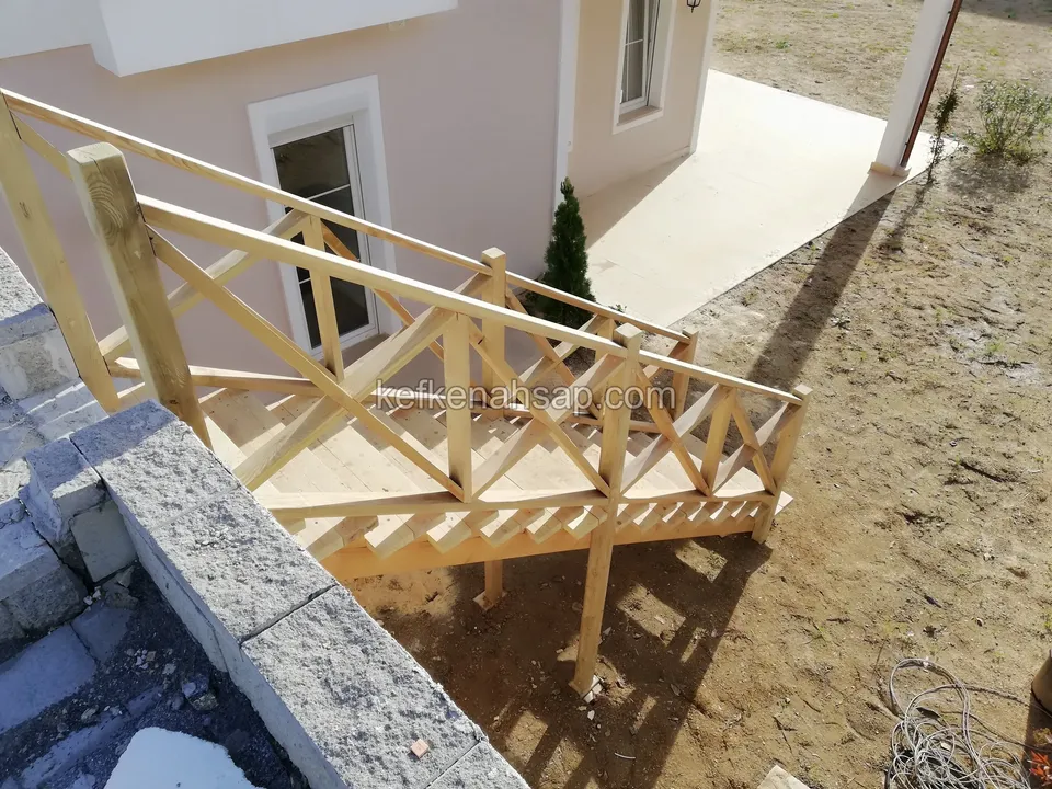 Holztreppe, Podest und Kreuzstreben-Geländer auf Stützen neben einer Haustür, mit Steinabdeckung