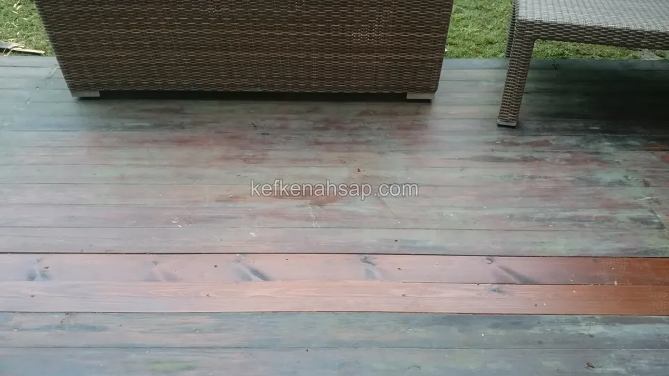 Grileşmiş eski deck yüzeyinde kızıl tonlu yeni bir tahta sırası, üstte hasır oturma elemanları