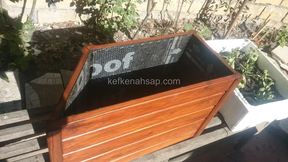 Güneşte duran, içi su yalıtım membranıyla kaplanmış turuncu vernikli ahşap çiçeklik