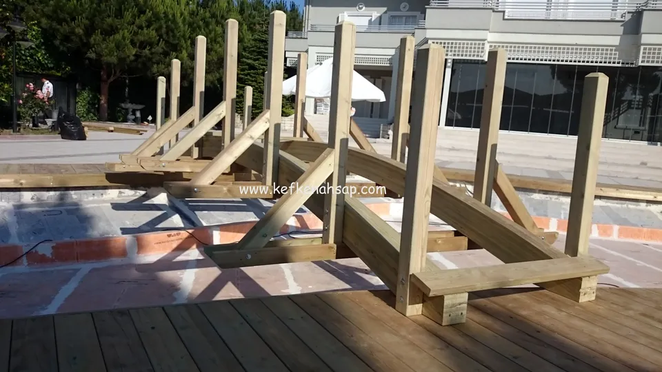 Havuz kenarında emprenyeli çam dikmeler ve taşıyıcı kirişler, önde döşenmiş deck tahtaları