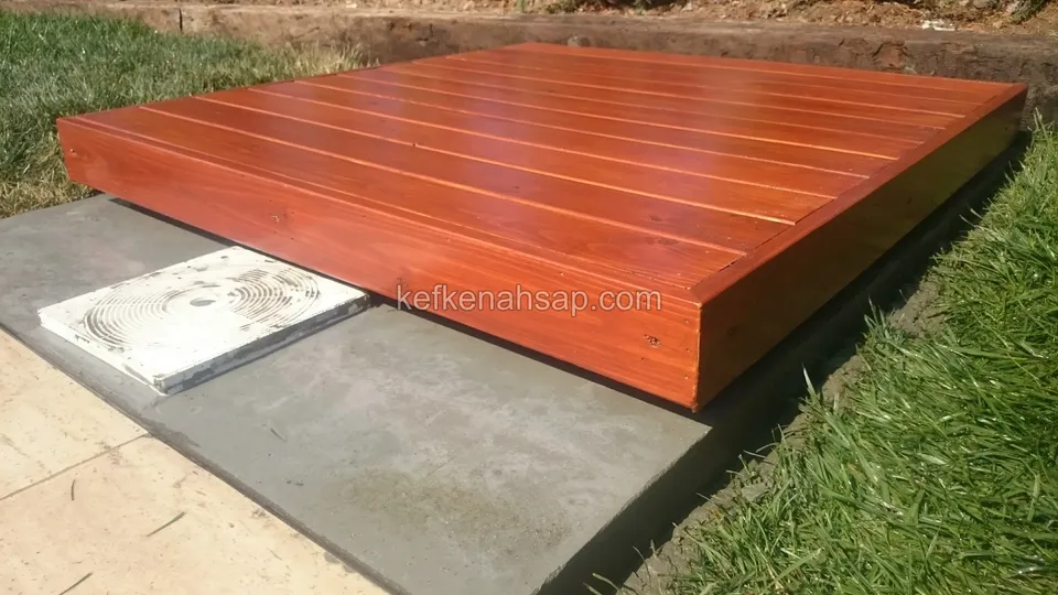 Side and top surface of a square timber deck platform beside a pool, with a concrete base and white cover next to it