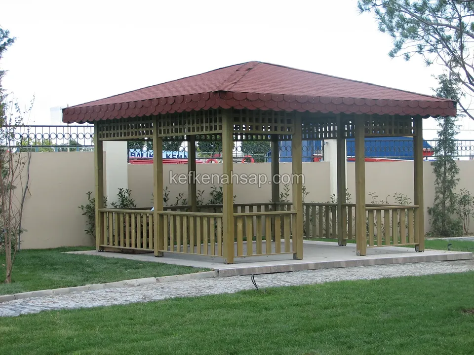 Kırmızı çatılı dört direkli ahşap kamelya, alçak çıtalı korkuluk, çatı altında kafes bordür ve çim