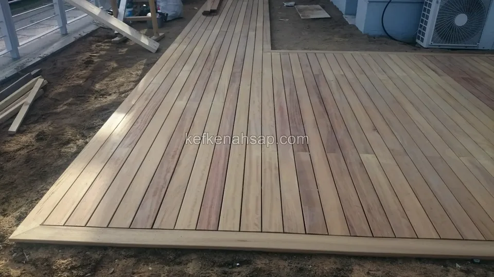 Partly finished deck floor with an air-conditioning unit at the top of the frame and offcuts on the ground