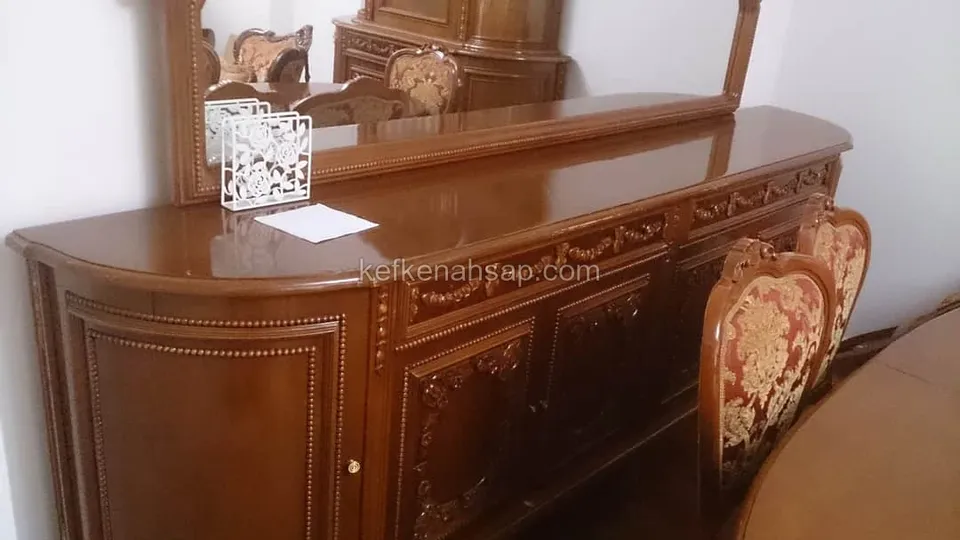Klassische Holzkonsole mit Schnitzereien und Perlstabprofil, darüber ein Spiegel, daneben Stühle mit rotem Stoffbezug