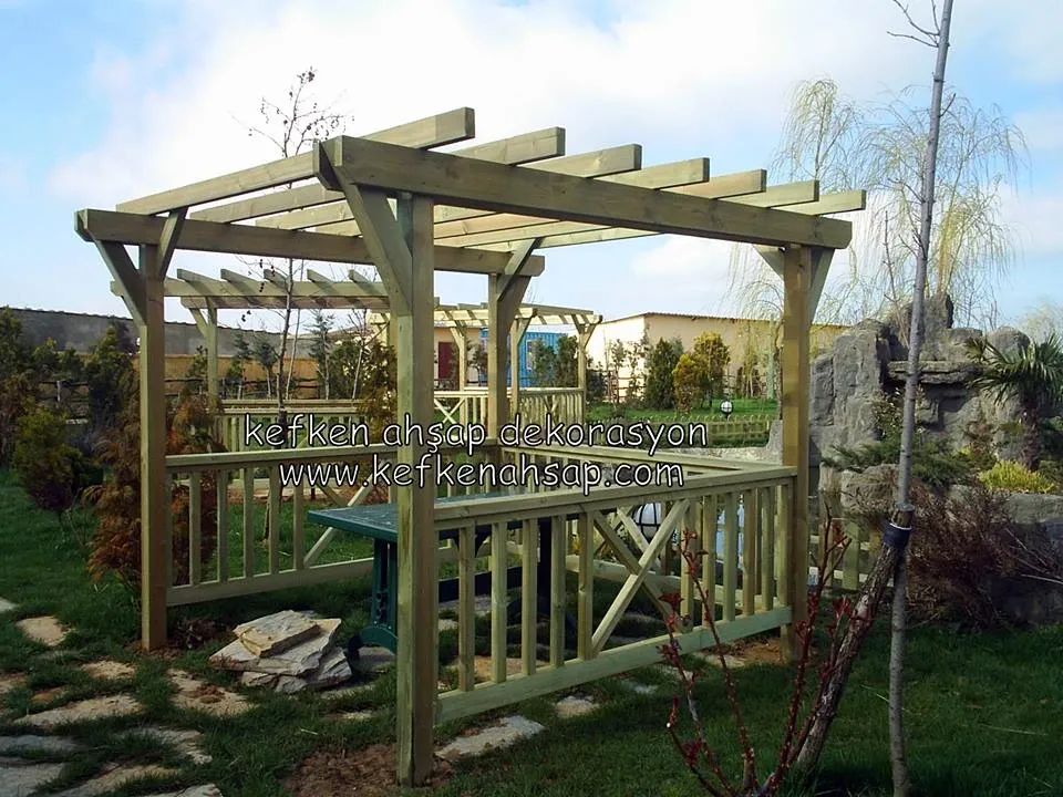 Bahçe içinde emprenye ahşaptan yapılmış, korkuluklu ve mertek çatılı açık pergola.