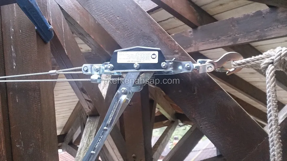 Koyu ahşap kirişlerin birleştiği noktada çelik halat gergisi ve halat, yakın çekim