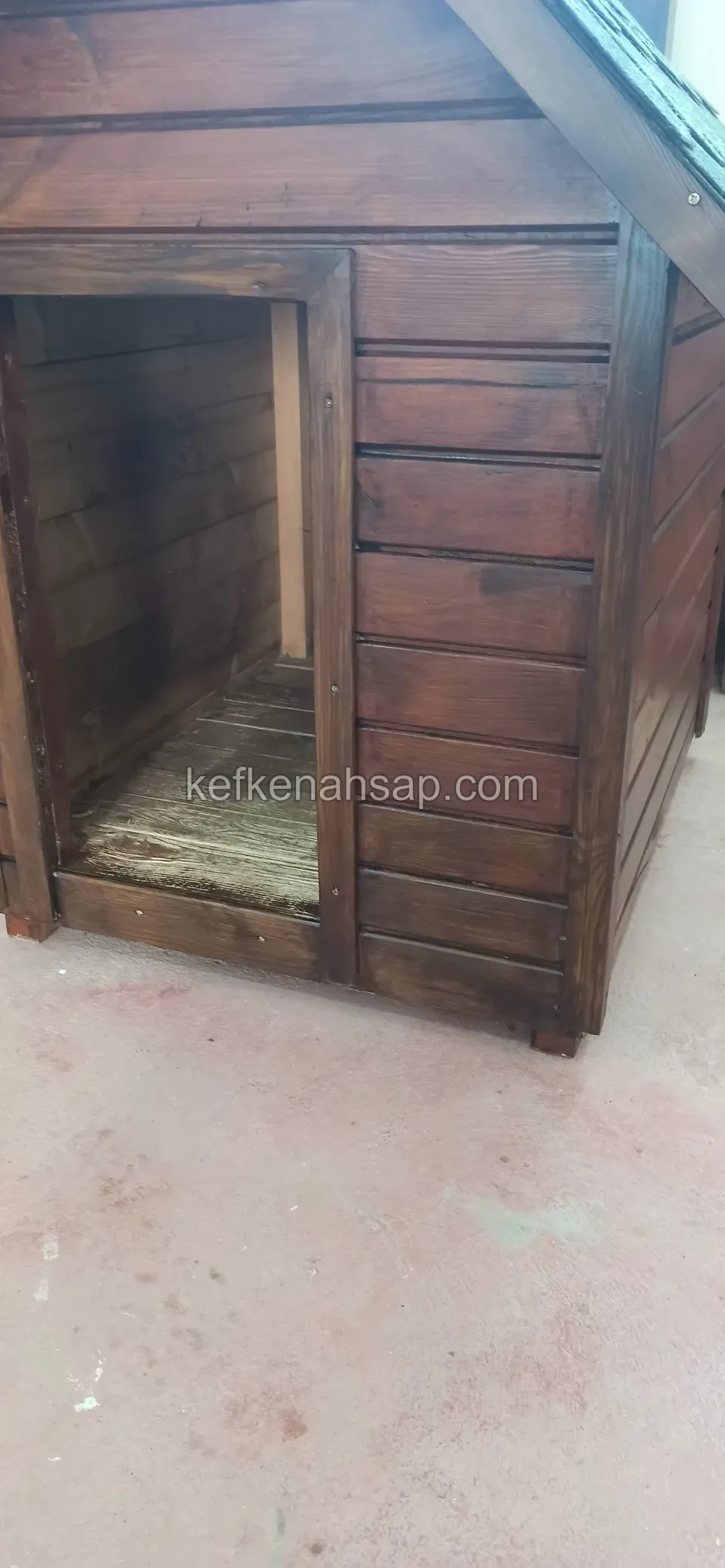 Köpek kulübesinin giriş açıklığı ve içindeki taban tahtaları, yatay vernikli kaplama