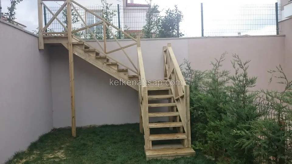 Çimenlikten başlayıp köşedeki sahanlıkta dönerek duvar üstüne çıkan ahşap merdiven