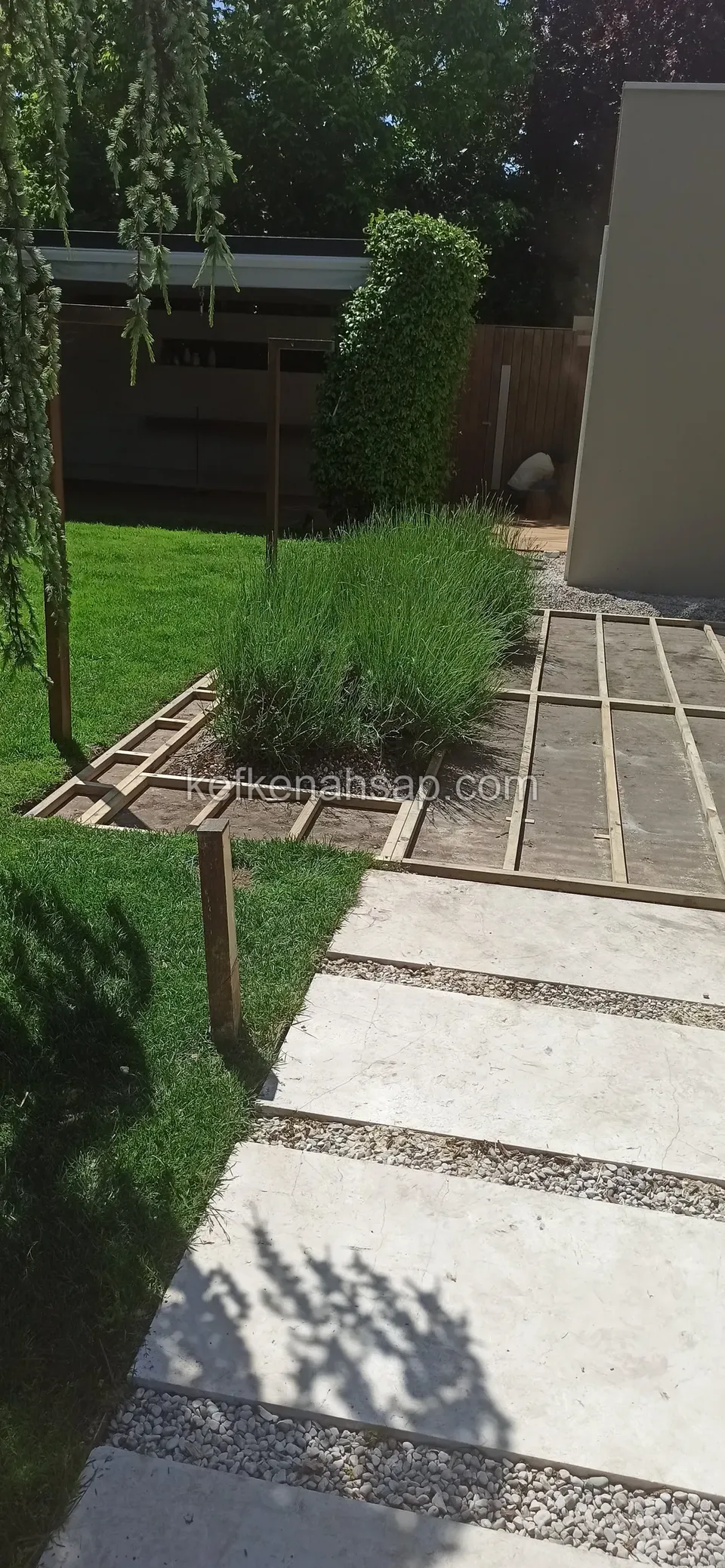 Lavanta yanında çakıl ve taş plakalı yürüyüş yolu ile başlayan deck çerçevesi, çimen kenarında