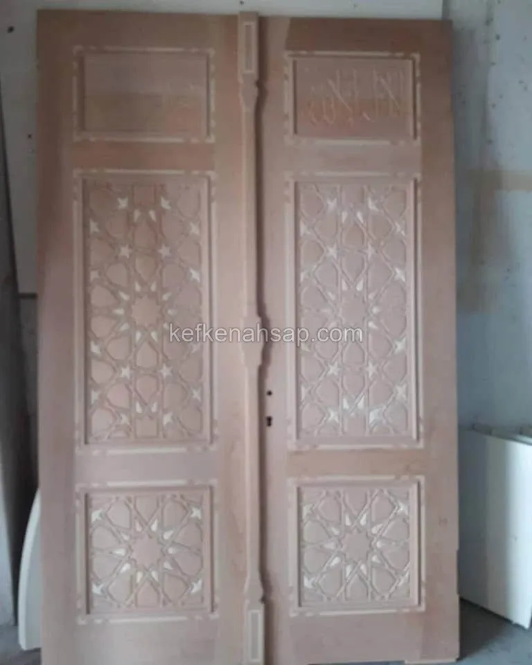 Atölyede zımparalanmış, geometrik yıldız motifli oymalara sahip masif ahşap çift kanat kapı.