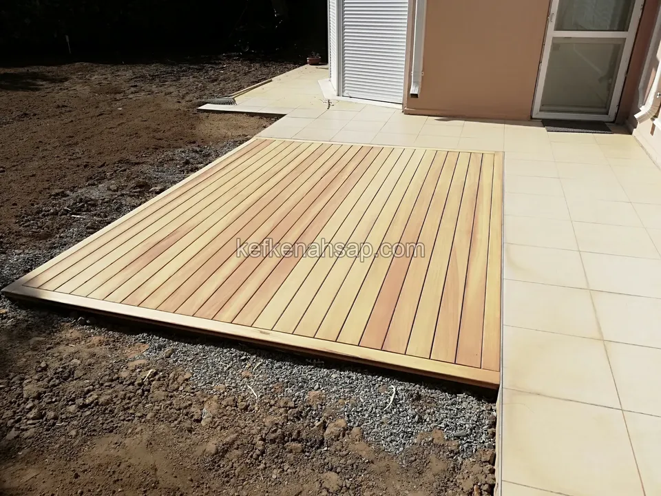 Light timber deck laid on a gravel bed next to a house's tiled patio