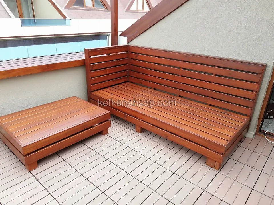 Glänzende rotbraune Holz-Ecksitzgruppe und niedriger Beistelltisch auf einer Terrasse mit hellen Fliesen