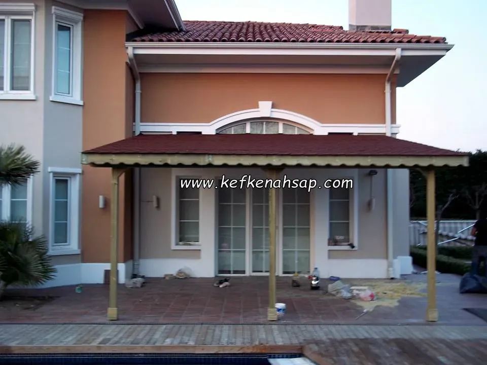 Müstakil evin havuz başı verandasına kurulan çatılı ahşap sundurma ve taşıyıcı direkler.