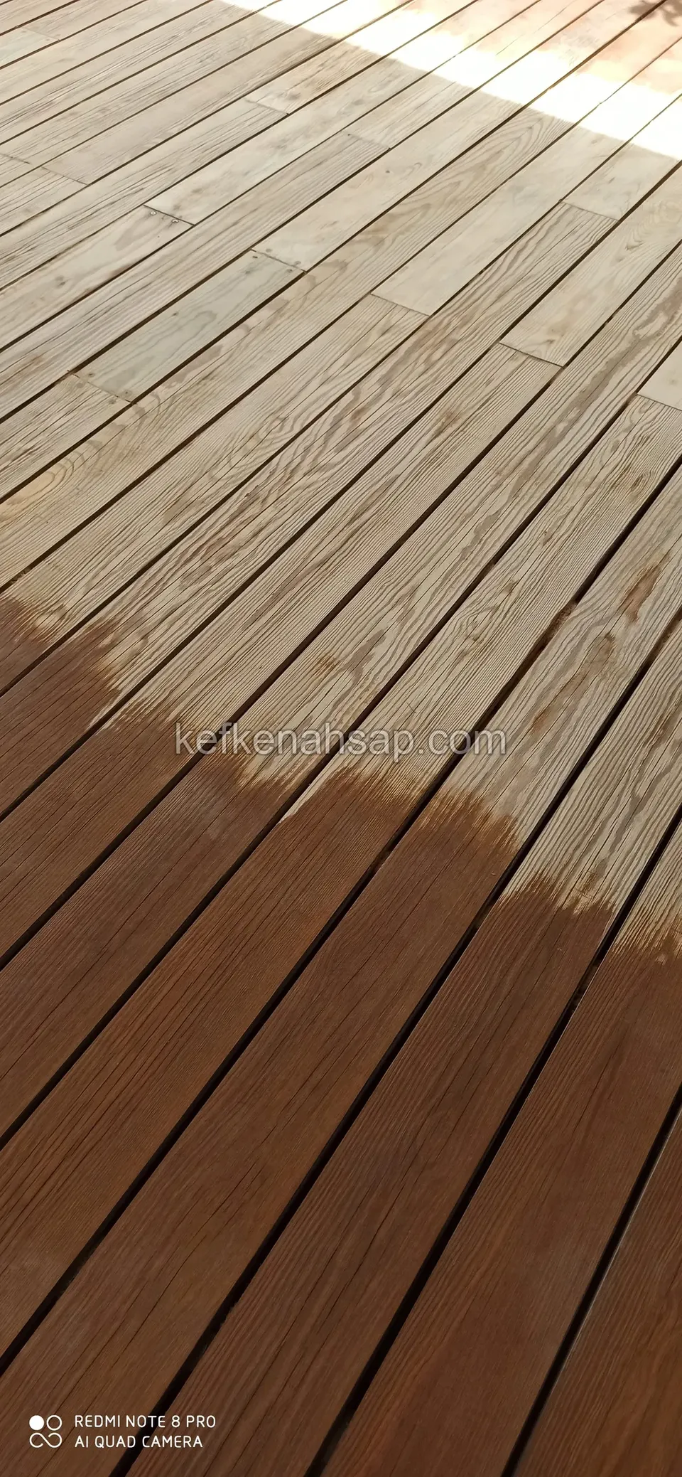 Deck boards with the left side sanded back to pale wood and the right side still dark brown