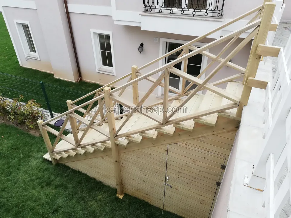 Yukarıdan görülen, çimenlik üzerinde altı kapaklı ahşap kaplamalı çapraz korkuluklu merdiven
