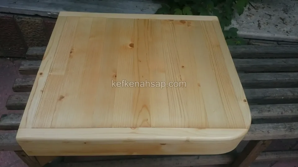 Nahaufnahme einer quadratischen Tischplatte aus massiven Kiefernbrettern mit abgerundeten Ecken